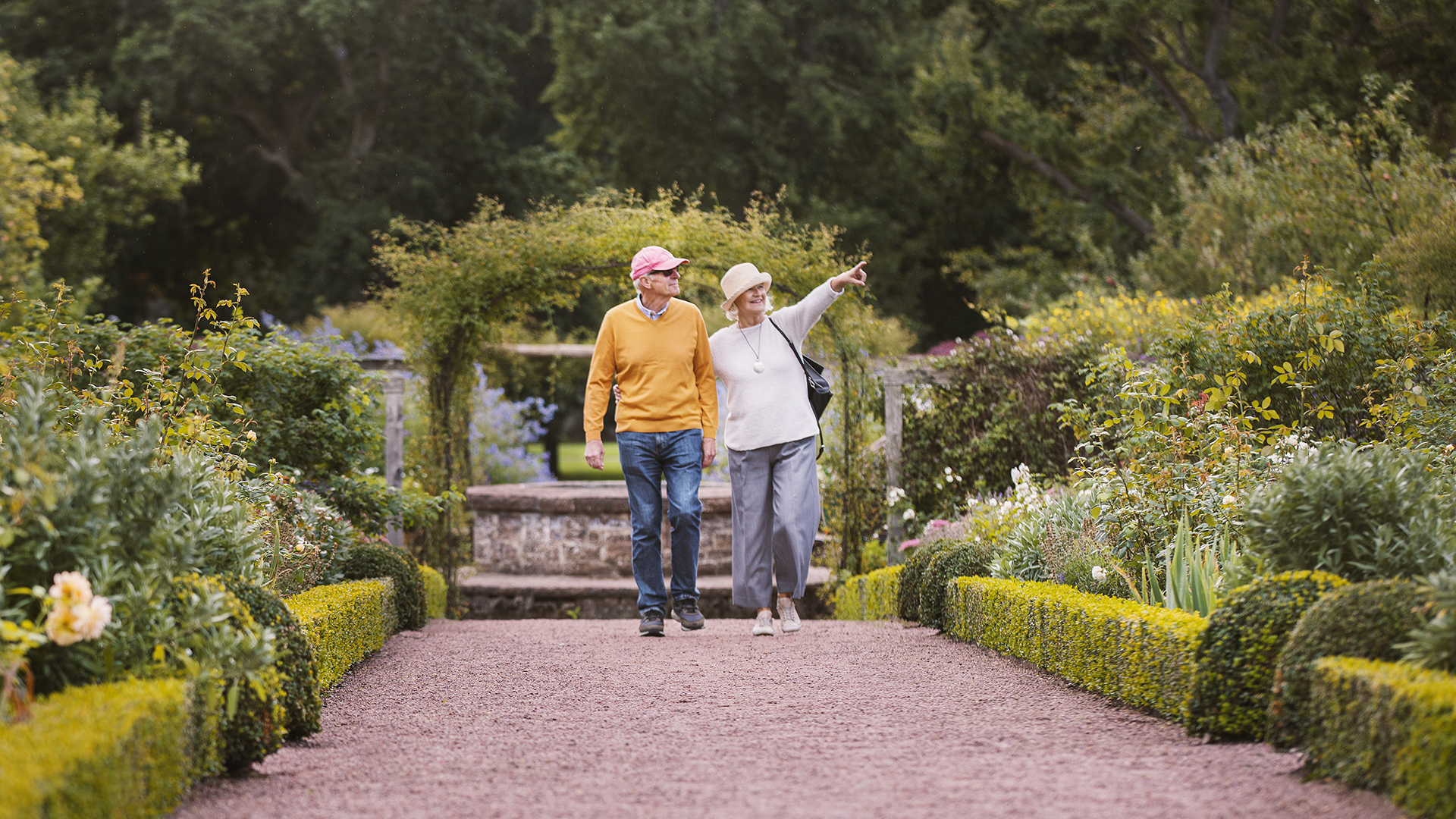 Äldre par som promenerar i slottsparken.