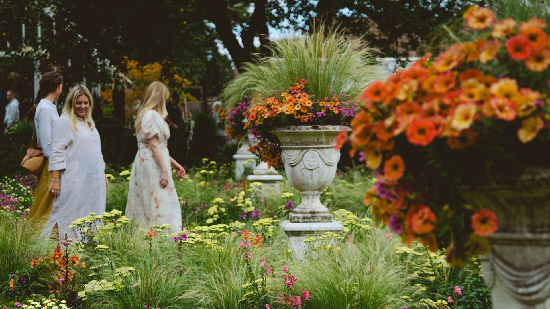 Tre kvinnor promenerar i slottsparkens grönska