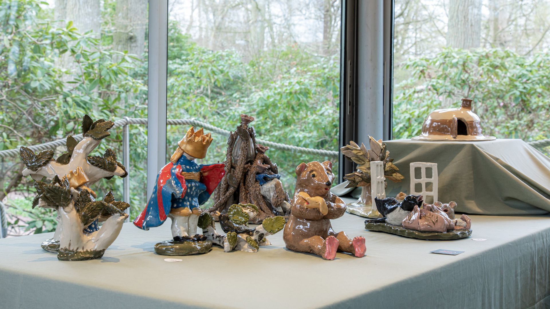 Porslinsfigurer i glaspaviljong